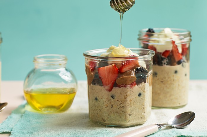 Overnight oats in glass jars, topped with fruit and honey