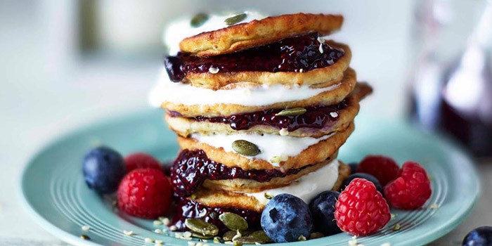 Stack of vegan protein pancakes with berries and yogurt