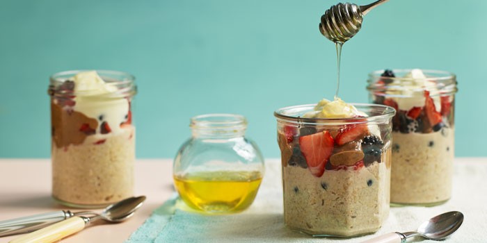 Three jars of overnight oats with fruit, yogurt and honey