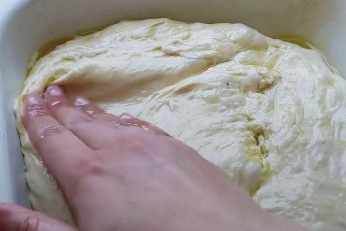 Hand pressing oiled dough