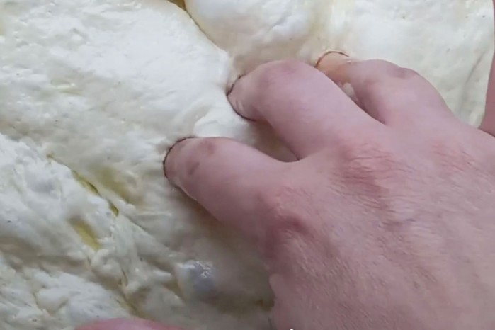 Fingers pressing dough